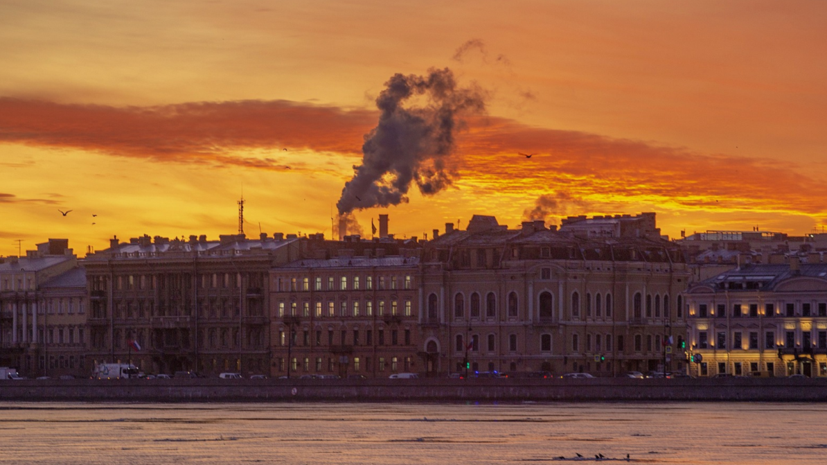 Saint Petersburg'da gün batımında tarihi binaların arka planında turuncu renkli gökyüzü.