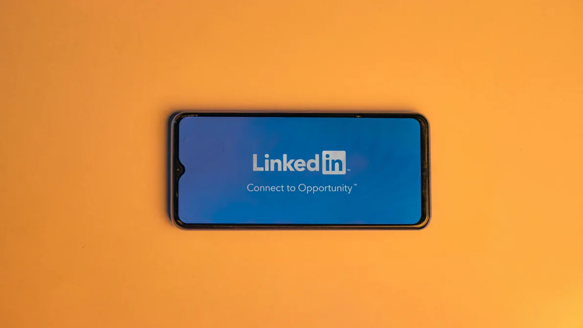 Bir akıllı telefon ekranında LinkedIn logosu ve "Connect to Opportunity" ifadesi görülüyor.